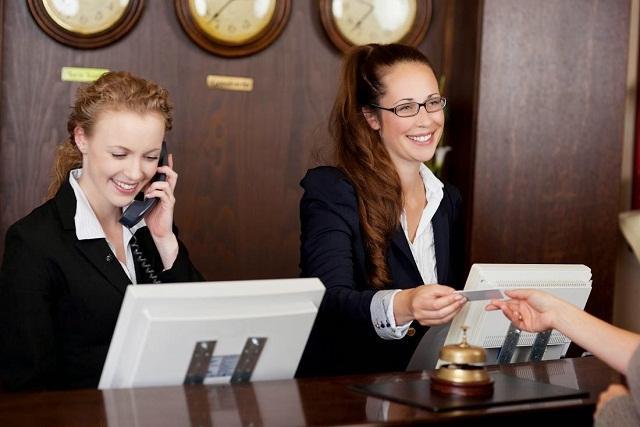 Nhân viên đặt phòng khách sạn đang hỗ trợ khách hàng đặt phòng