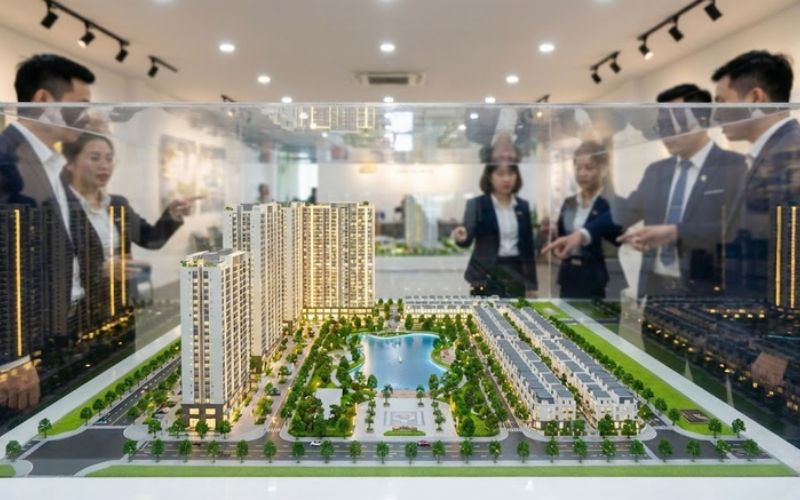 Nhân viên tư vấn giới thiệu mô hình dự án bất động sản cho khách hàng